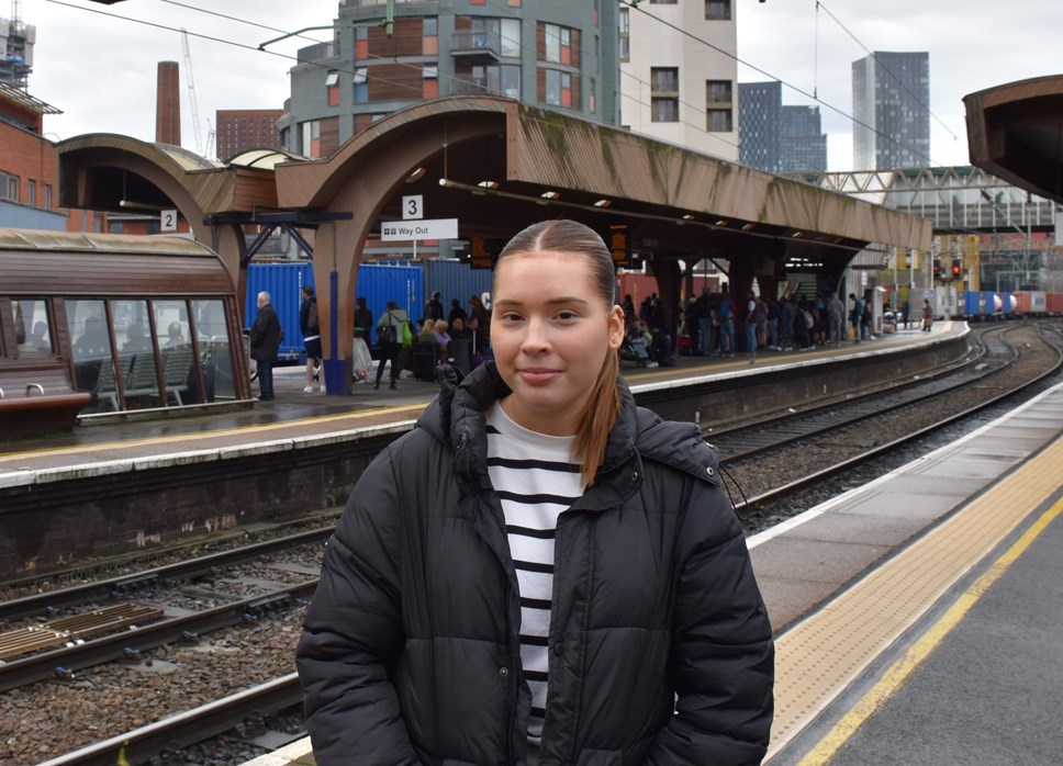 Women smiling at camera at a train station