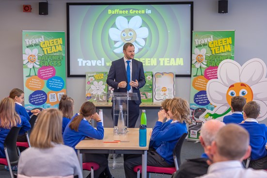 A man in a suit presents to children at a school