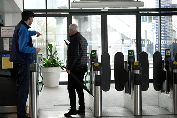 Rail station staff member helping a customer